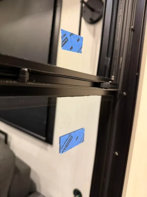 Closeup of masking tape on dual panes showing gap difference between correctly and incorrectly installed glass